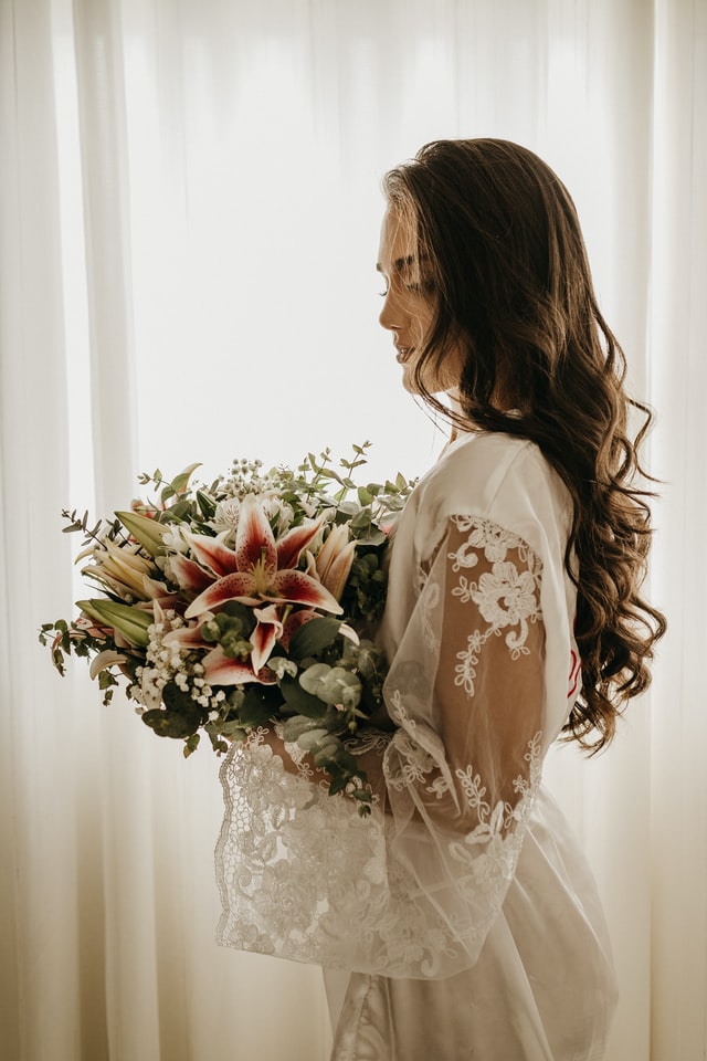 Bride holding pink lilies bouquet